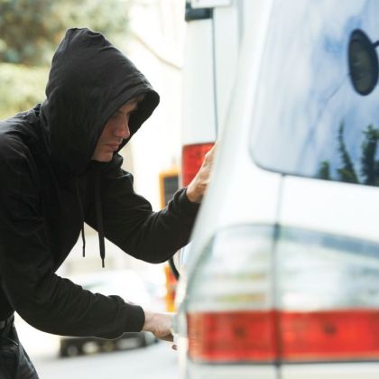 Thief stealing automobile car at daylight street in city